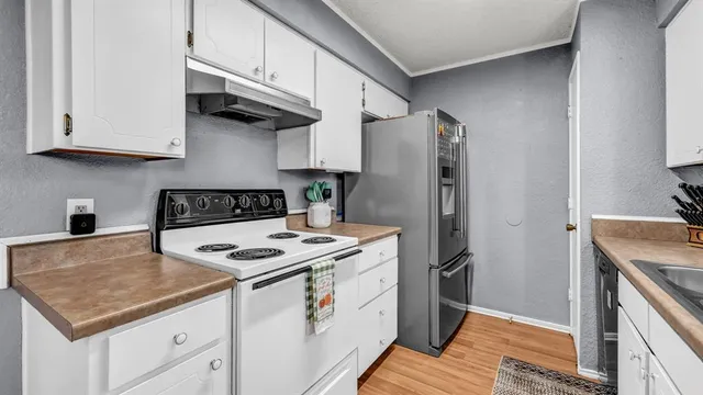 a kitchen with stainless steel appliances granite countertop a stove a refrigerator and a cabinets