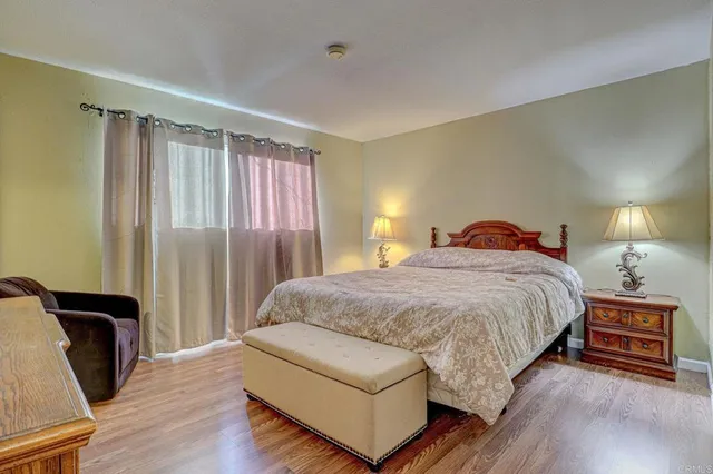 a spacious bedroom with a bed and wooden floor