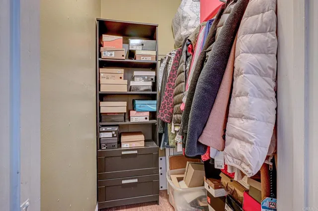 a view of walk in closet with clothes and shoes