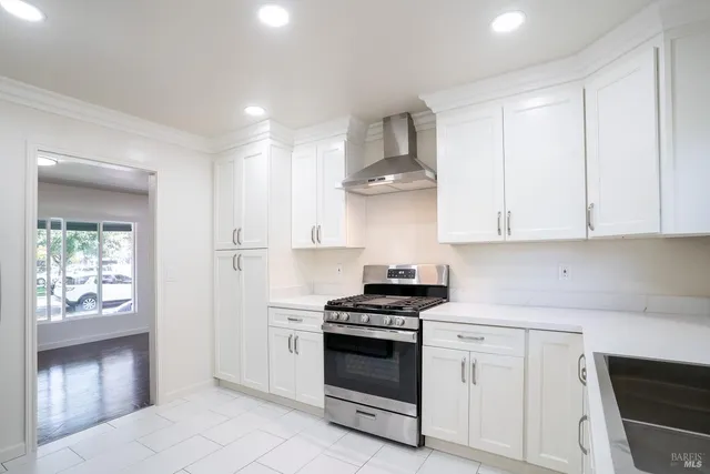 a kitchen with white cabinets and appliances
