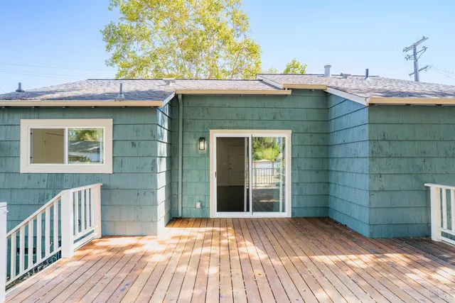 a view of a house with a wooden deck