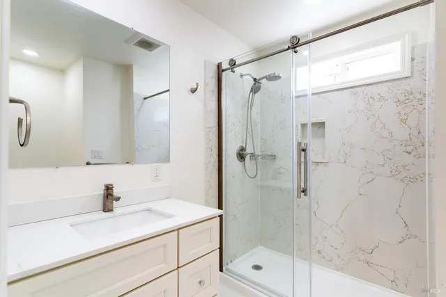a bathroom with a shower sink and mirror