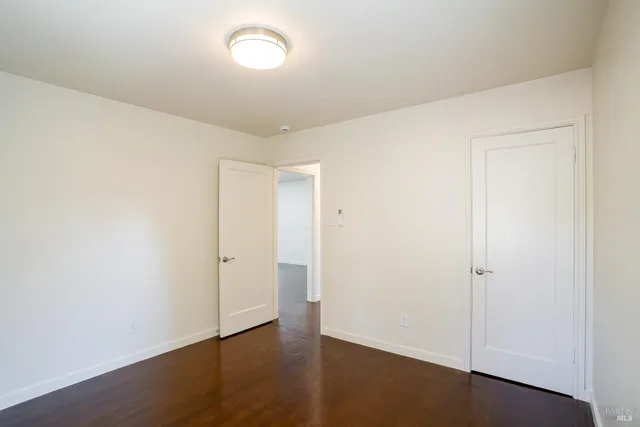 an empty room with wooden floor and white walls