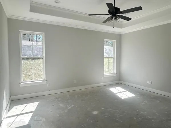 an empty room with windows and fan