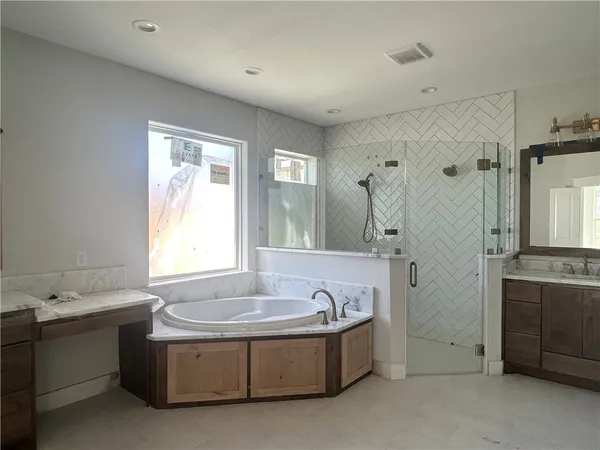 a spacious bathroom with sink shower and bathtub
