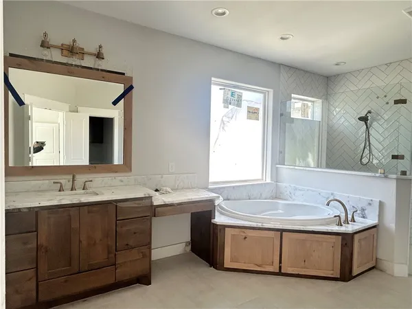 a bathroom with a tub sink and mirror