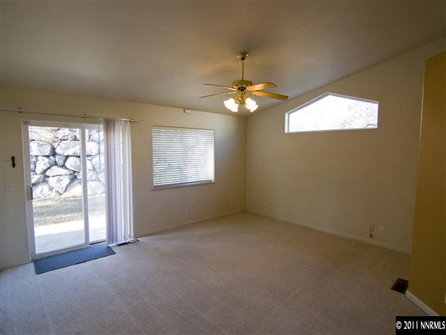 2225 Ridgeview Drive Reno, NV 89519 - Photo 6 of 12 an empty room with windows and chandelier fan
