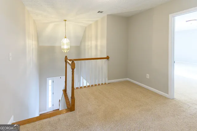 a view of a hallway to rooms and stairs
