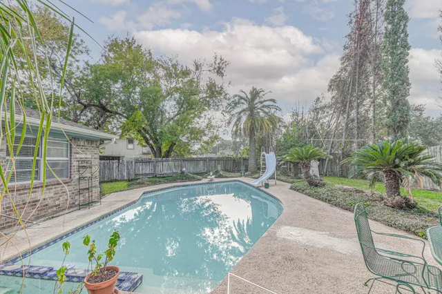 a view of a swimming pool with a patio and couches