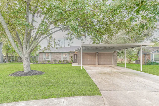 front view of a house with a yard and an trees