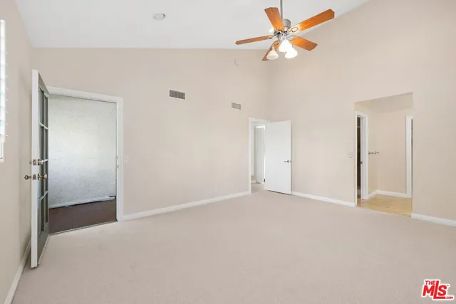 an empty room with closet and fan