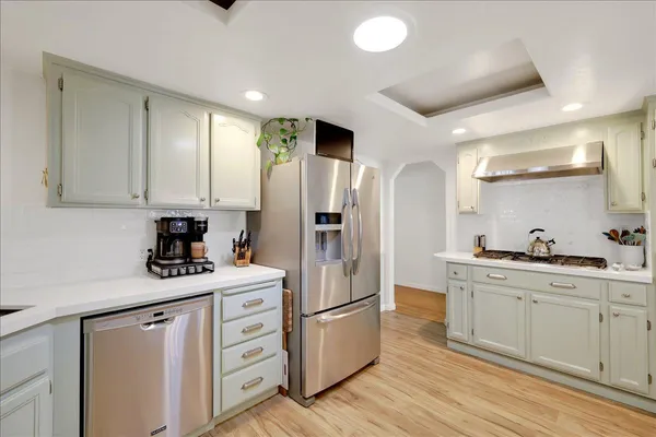 a kitchen with white cabinets and stainless steel appliances
