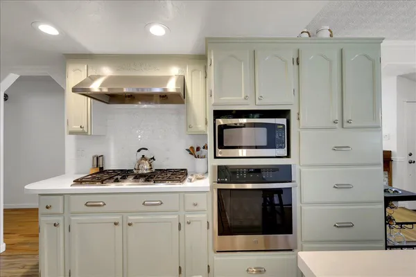 a kitchen with stainless steel appliances granite countertop a stove and a microwave