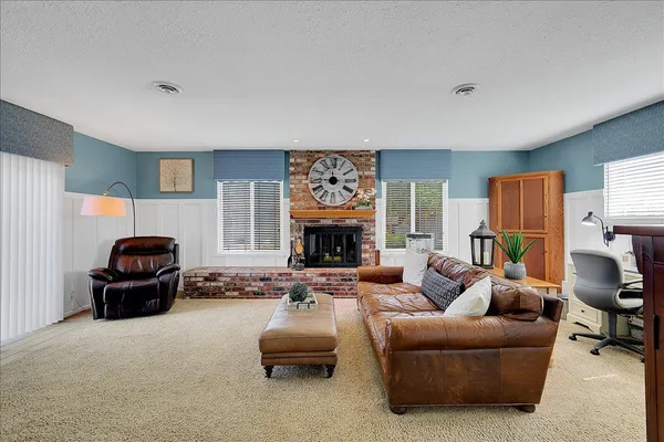 a living room with furniture large window and a fireplace
