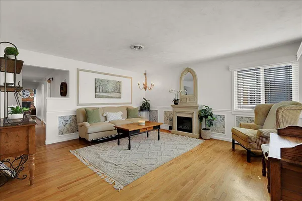 a living room with furniture a fireplace and a large window