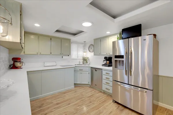 a kitchen with a refrigerator cabinets and wooden floor