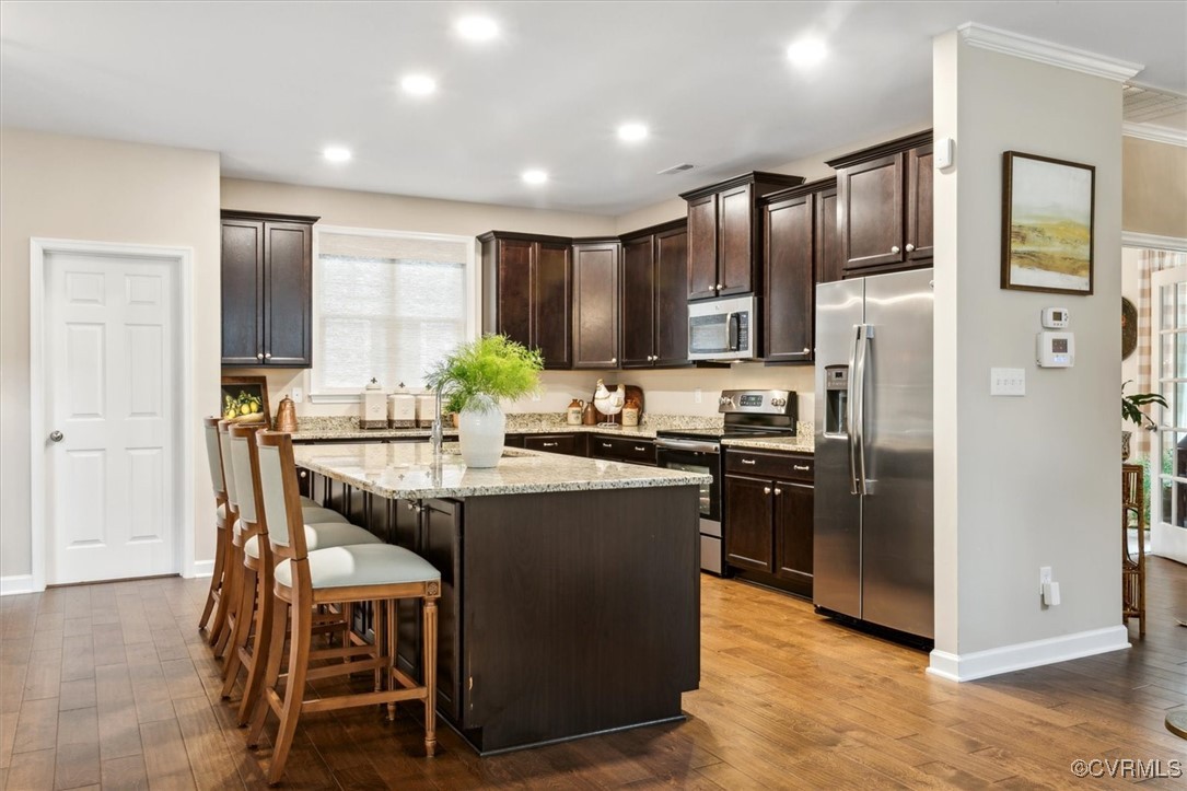 5587 Brixton Road Williamsburg, VA 23185 - Photo 14 of 42 a kitchen with stainless steel appliances granite countertop a refrigerator a sink a stove a dining table and chairs