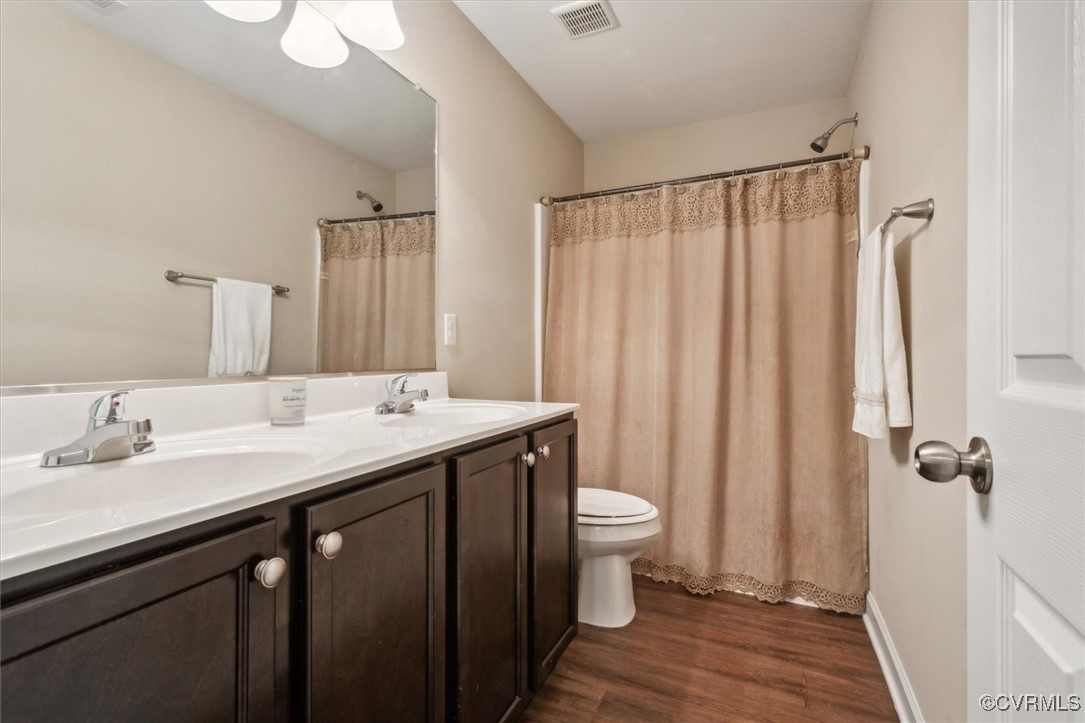 5587 Brixton Road Williamsburg, VA 23185 - Photo 27 of 42 a bathroom with a double vanity sink toilet and a mirror