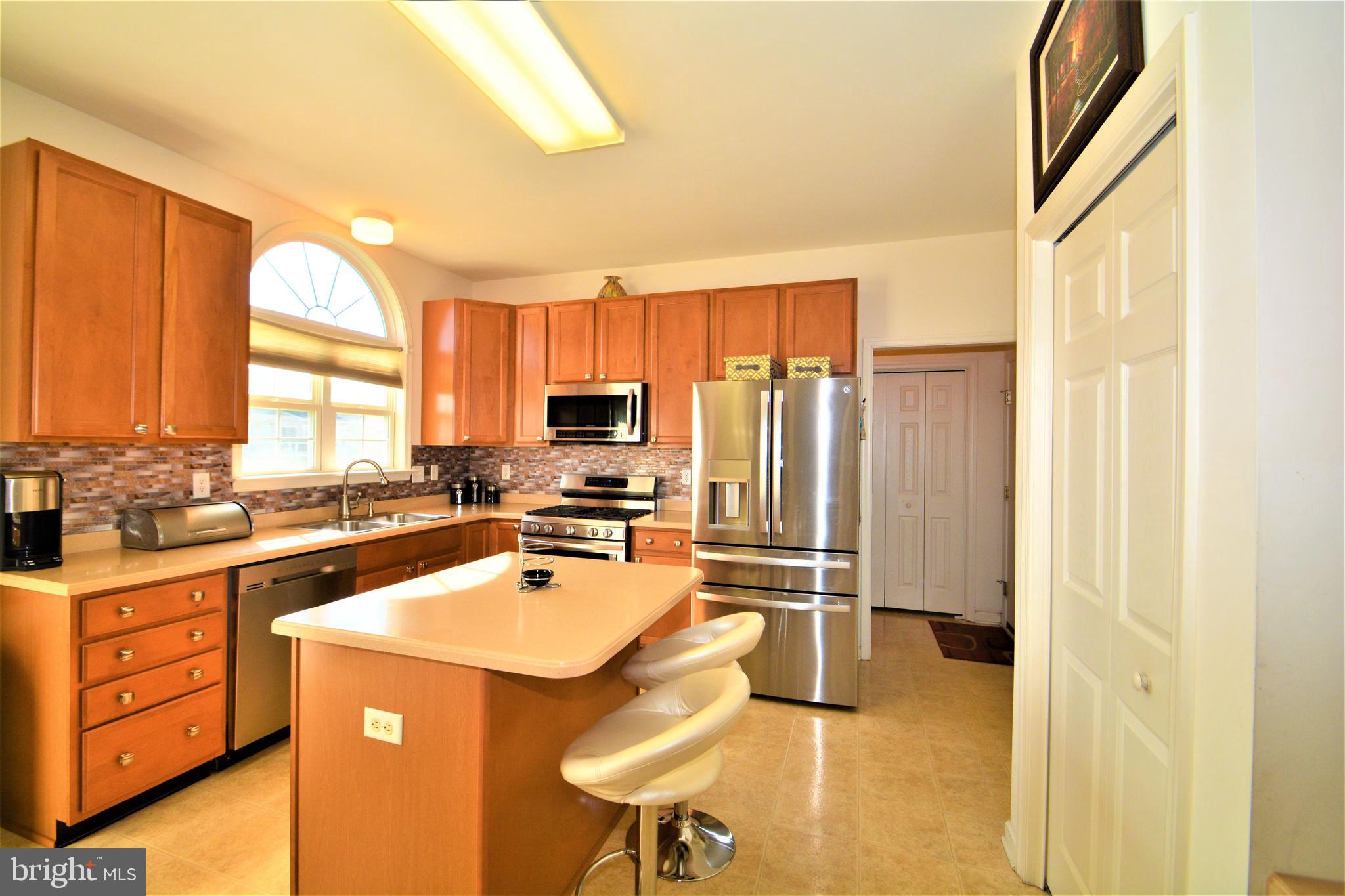176 Gravelly Run Branch Road Clayton, DE 19938 - Photo 19 of 52 a kitchen with a refrigerator a stove a sink dishwasher and wooden cabinets with wooden floor
