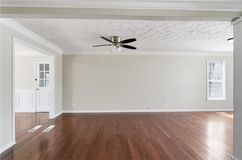 2366 Flint Rock Road Southwest Stone Mountain, GA 30087 - Photo 15 of 40 an empty room with wooden floor and a ceiling fan