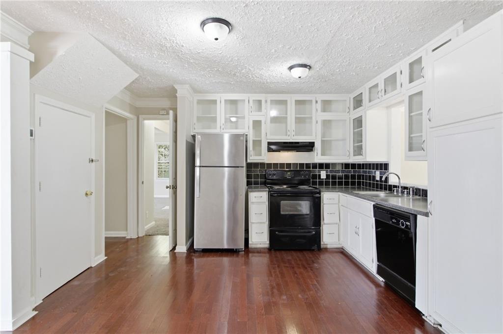 2366 Flint Rock Road Southwest Stone Mountain, GA 30087 - Photo 16 of 40 a kitchen with granite countertop a refrigerator and a stove top oven