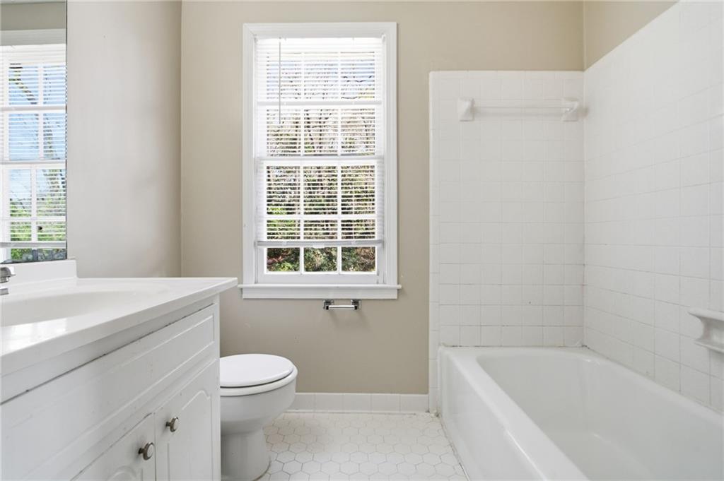 2366 Flint Rock Road Southwest Stone Mountain, GA 30087 - Photo 27 of 40 a bathroom with a granite countertop toilet a sink and bathtub