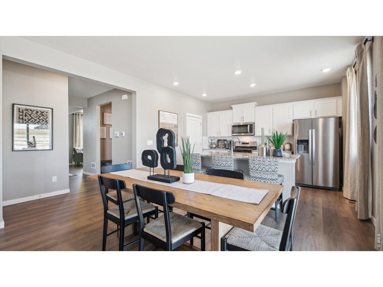 2338 Base Street Fort Lupton, CO 80621 - Photo 4 of 24 a kitchen with stainless steel appliances kitchen island granite countertop a dining table chairs and a refrigerator
