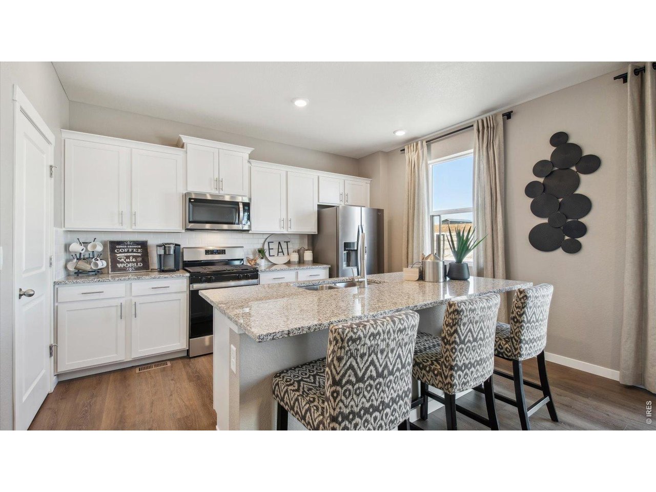2338 Base Street Fort Lupton, CO 80621 - Photo 7 of 24 a kitchen with kitchen island granite countertop a stove a sink a dining table and chairs