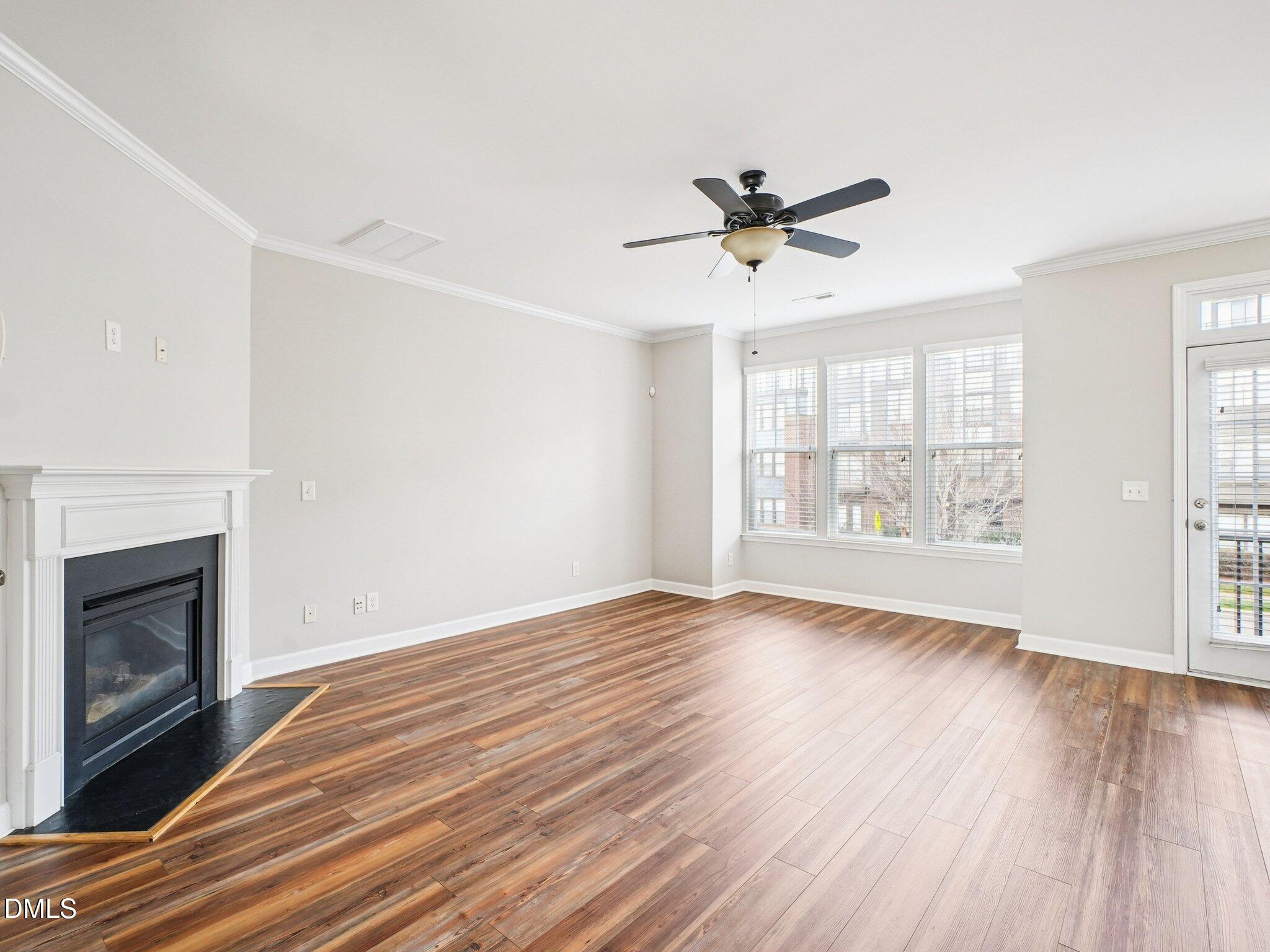 9238 Wooden Road Raleigh, NC 27617 - Photo 13 of 45 an empty room with wooden floor fan and windows