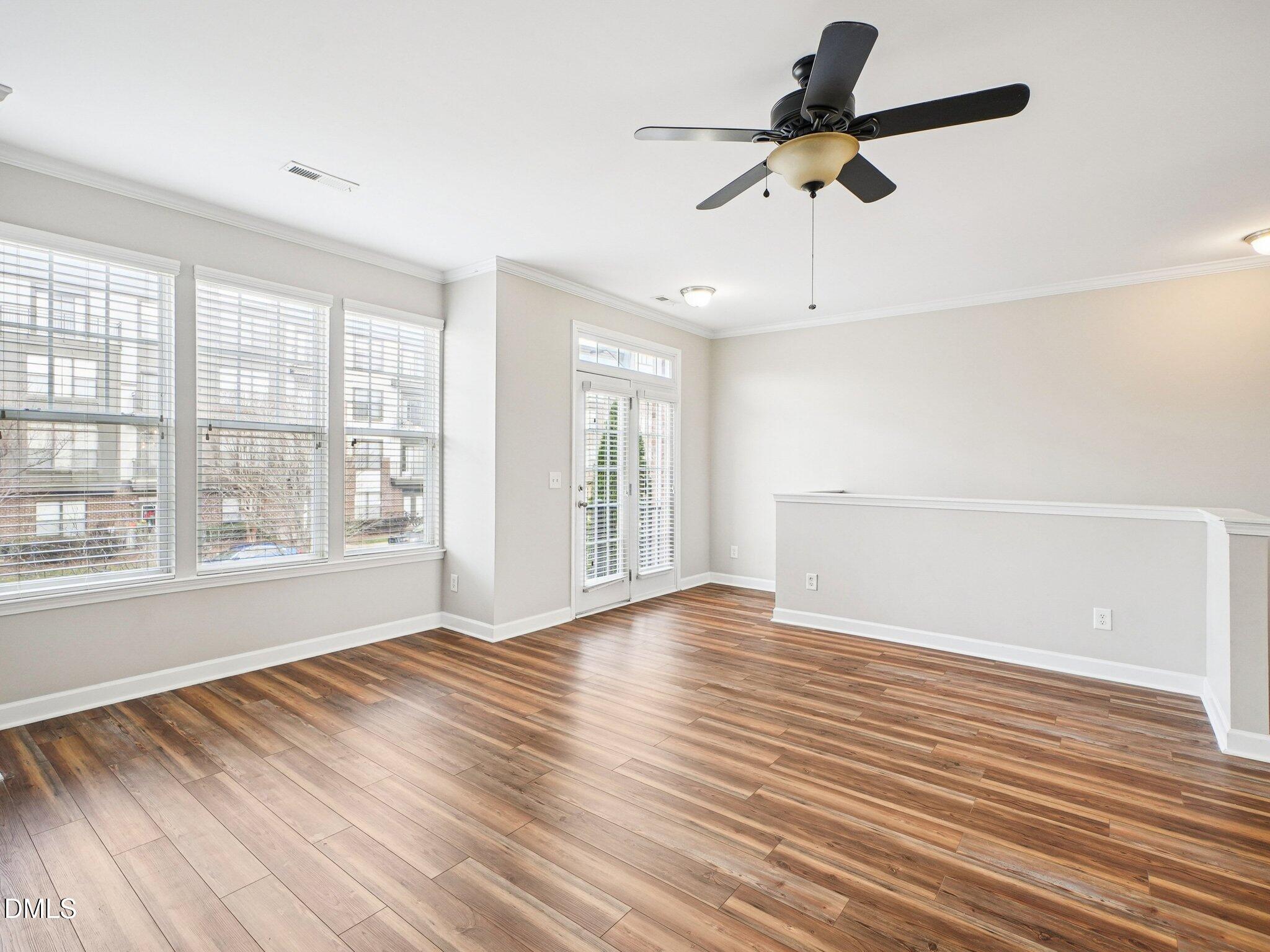 9238 Wooden Road Raleigh, NC 27617 - Photo 14 of 45 a view of an empty room with a window and wooden floor