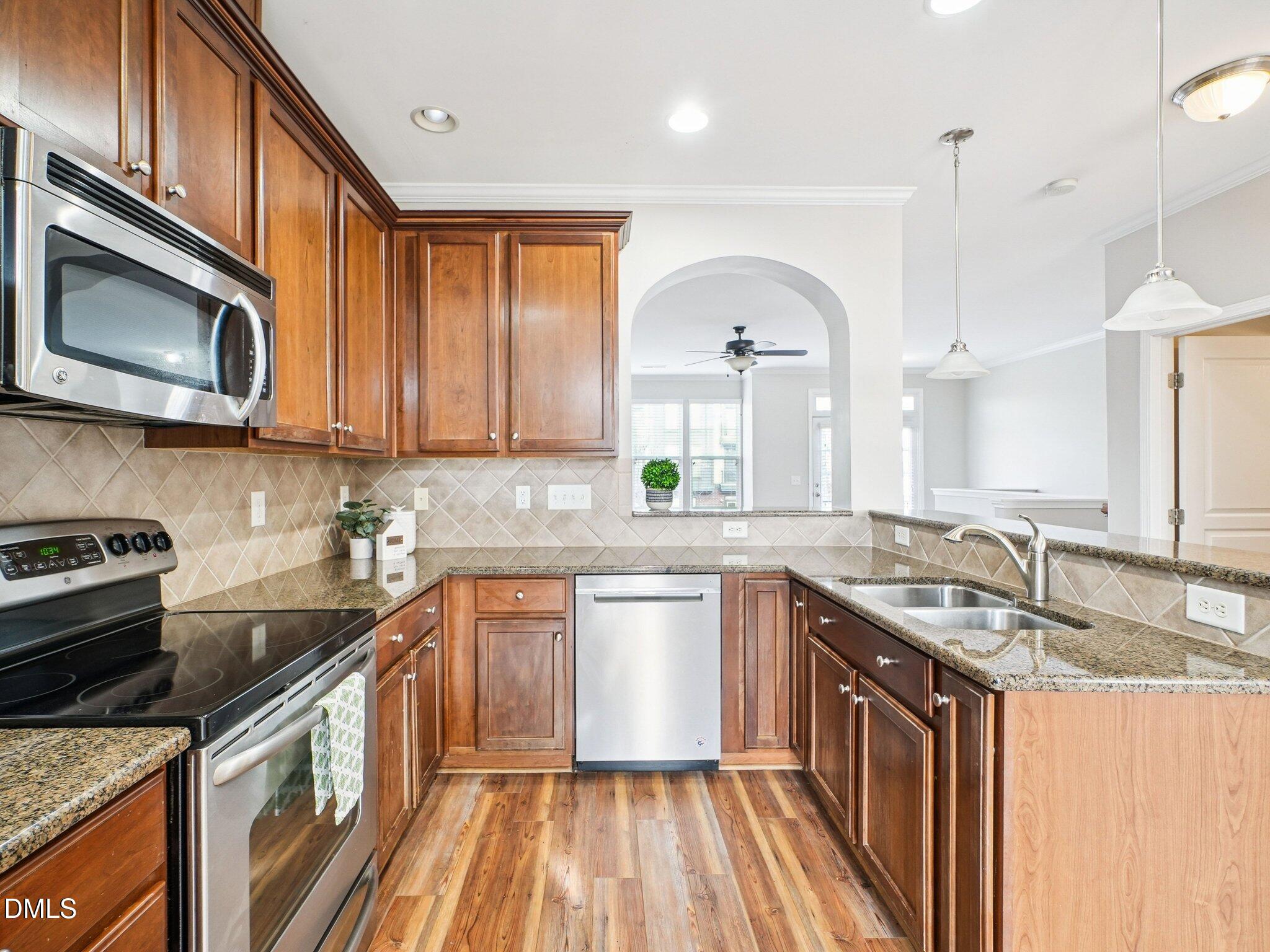 9238 Wooden Road Raleigh, NC 27617 - Photo 19 of 45 a kitchen with stainless steel appliances granite countertop a sink stove and cabinets