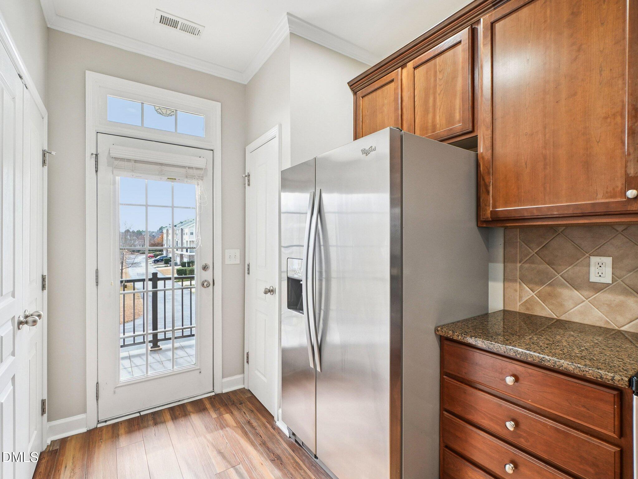 9238 Wooden Road Raleigh, NC 27617 - Photo 20 of 45 a kitchen with granite countertop a refrigerator and a wooden floor