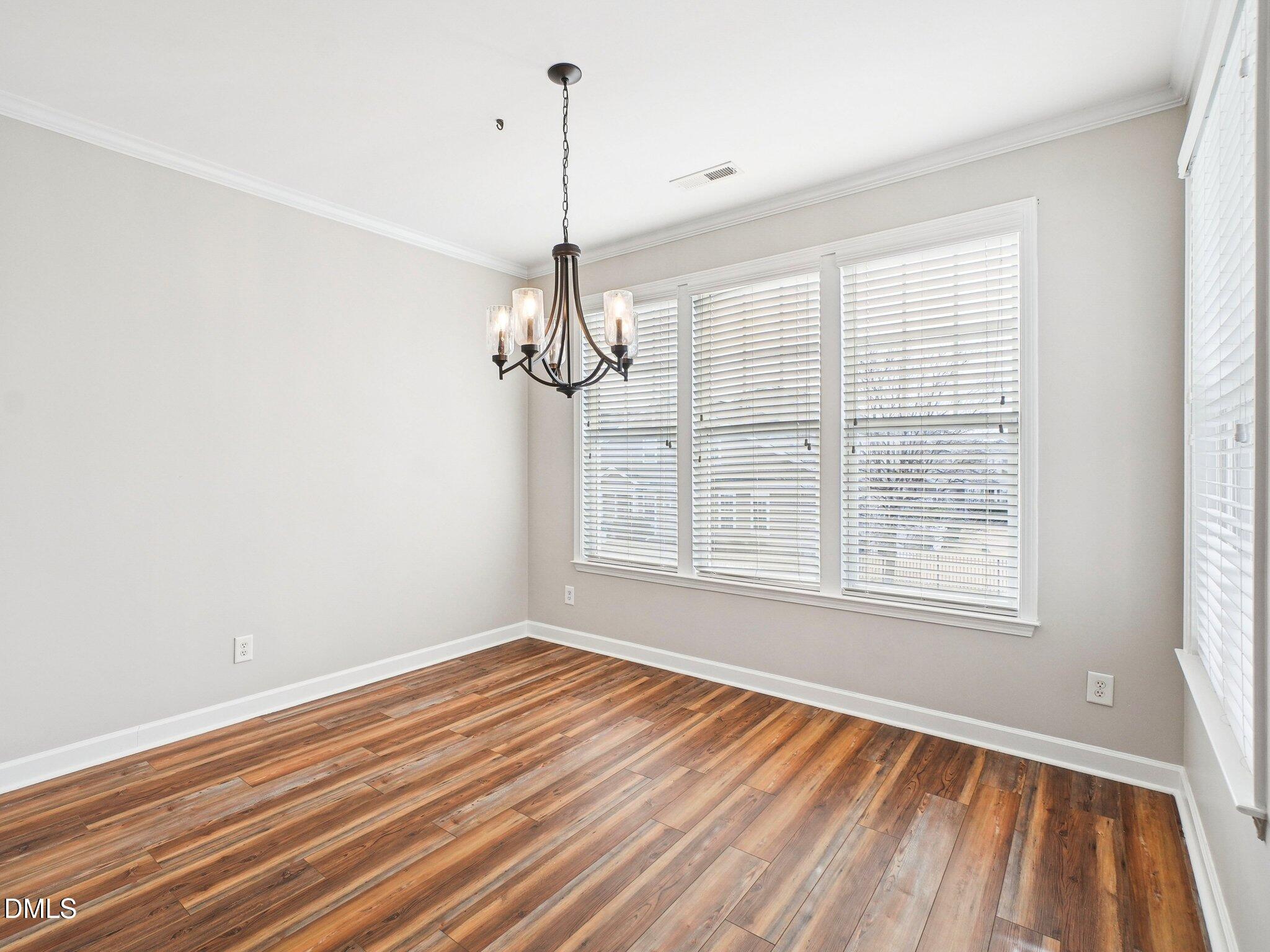 9238 Wooden Road Raleigh, NC 27617 - Photo 24 of 45 a view of an empty room with wooden floor and a window
