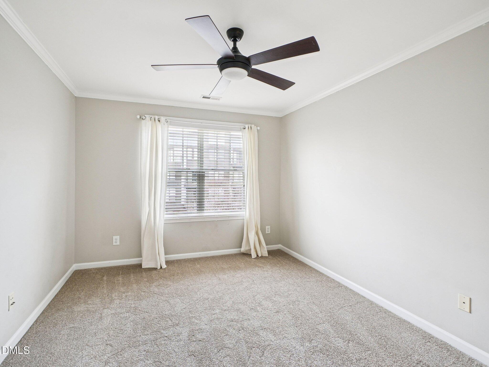 9238 Wooden Road Raleigh, NC 27617 - Photo 34 of 45 an empty room with ceiling fan and windows