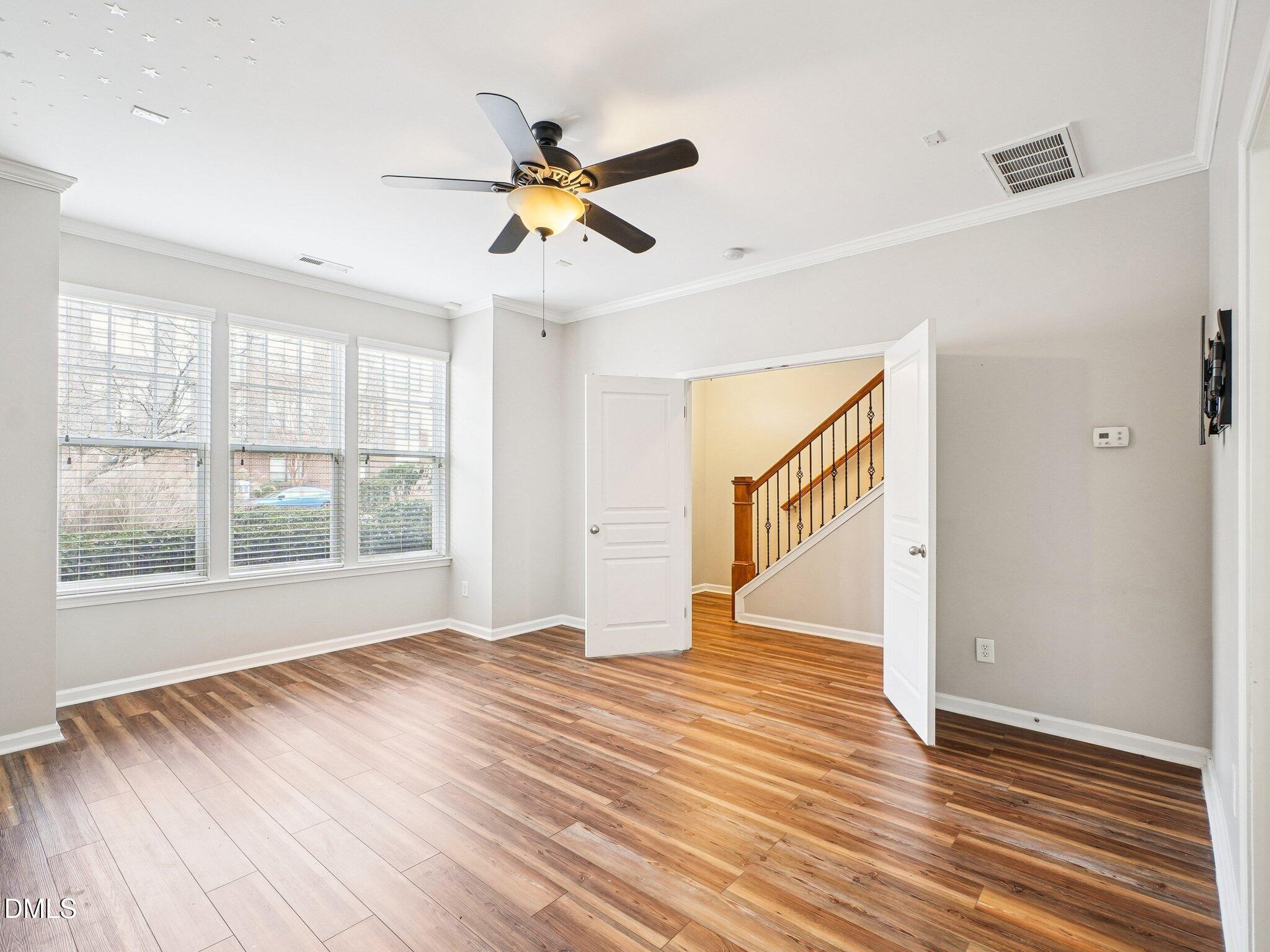 9238 Wooden Road Raleigh, NC 27617 - Photo 7 of 45 a view of an empty room with wooden floor and a window