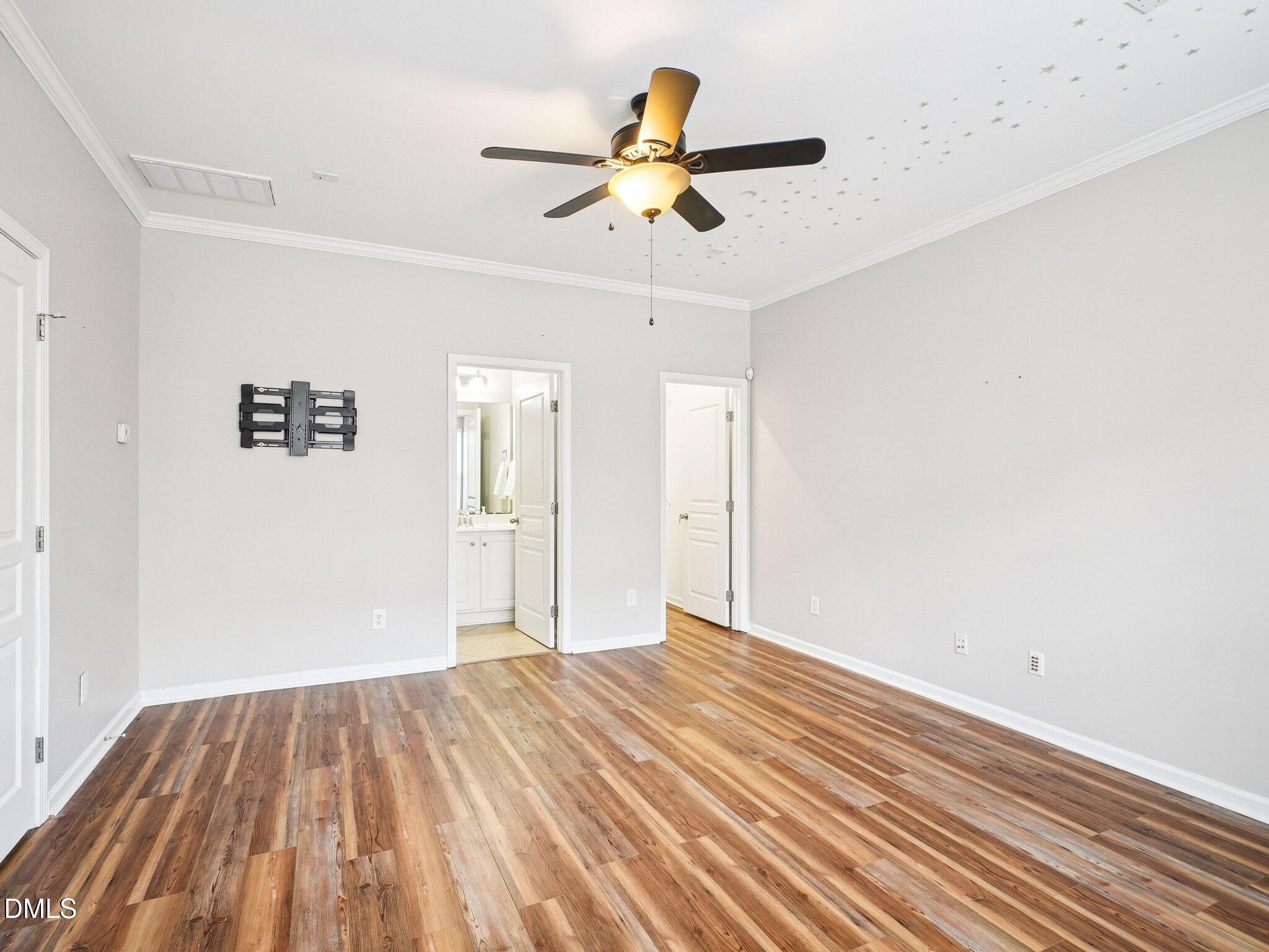 9238 Wooden Road Raleigh, NC 27617 - Photo 8 of 45 a view of a room with wooden floor and a ceiling fan