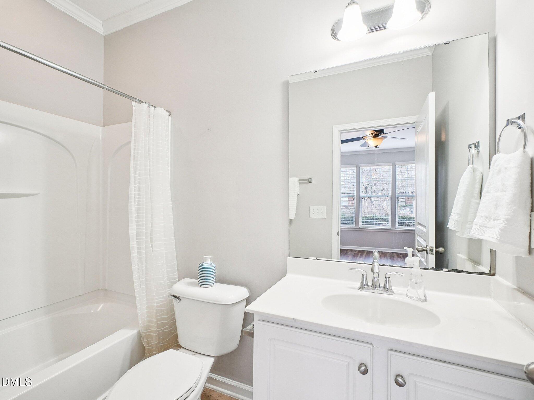 9238 Wooden Road Raleigh, NC 27617 - Photo 9 of 45 a bathroom with a sink toilet mirror and shower