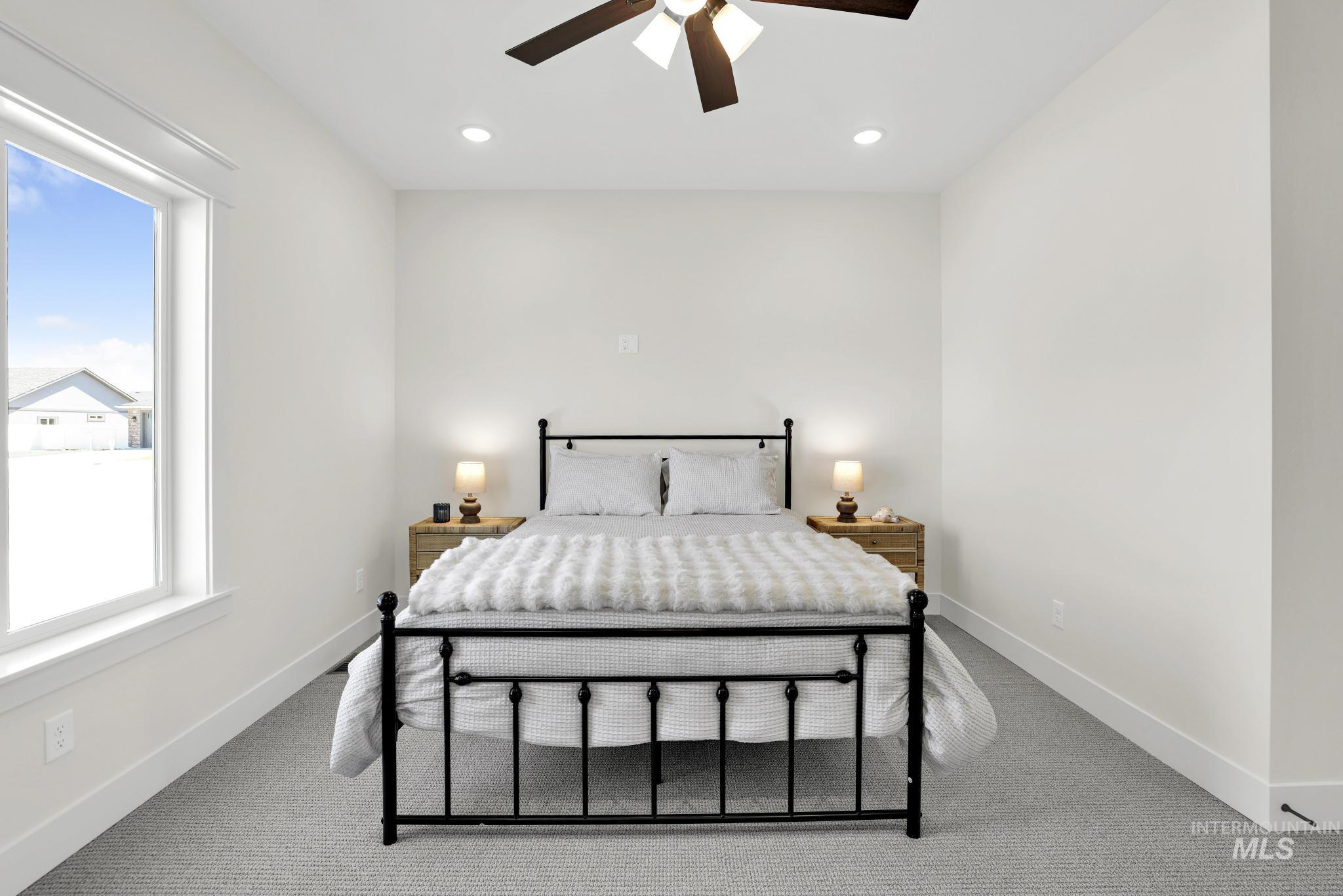 284 Sandi Road Twin Falls, ID 83301 - Photo 24 of 33 Neutral tone wall paint with white trim, light gray textured carpet, and a ceiling fan with integrated lighting