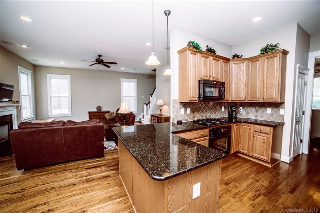 3388 Richard's Crossing Fort Mill, SC 29708 - Photo 14 of 36 a kitchen with kitchen island granite countertop a stove top oven a sink dishwasher a dining table and chairs with wooden floor