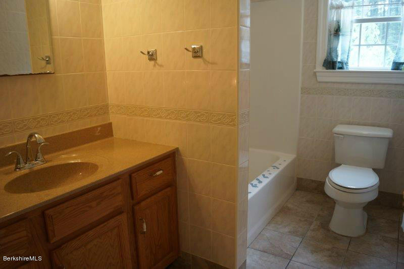 708 Clayton Road Sheffield, MA 01222 - Photo 14 of 19 a bathroom with a granite countertop toilet a sink and mirror