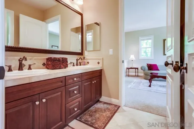 a en suite bathroom with double vanity sinks and a mirror