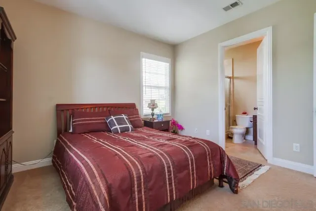 a bed sitting in a bedroom next to a window