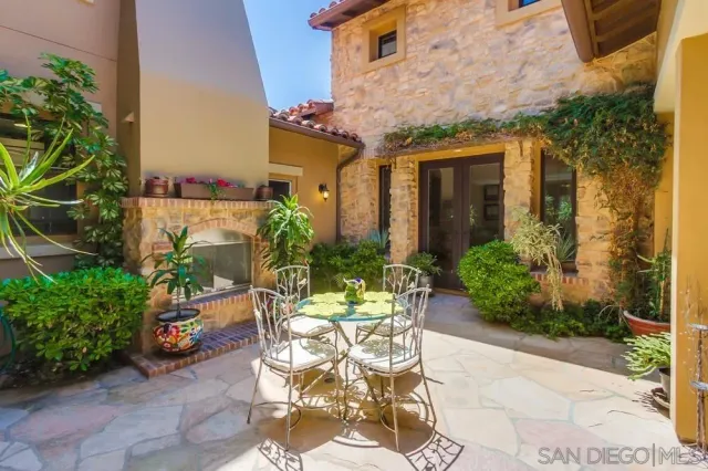 a view of a patio with table and chairs potted plants