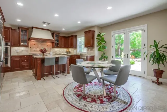 a living room with kitchen island furniture a large window and a fireplace
