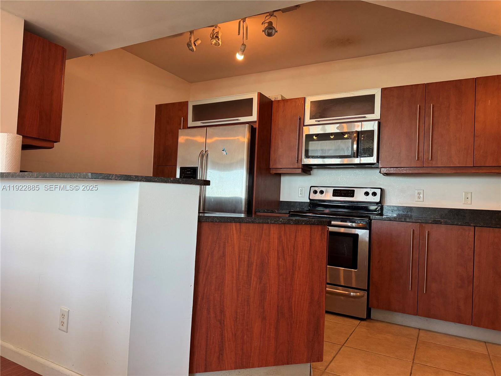 7350 Southwest 89th Street, Unit 1801S Miami, FL 33156 - Photo 3 of 15 a kitchen with stainless steel appliances a refrigerator and a stove top oven