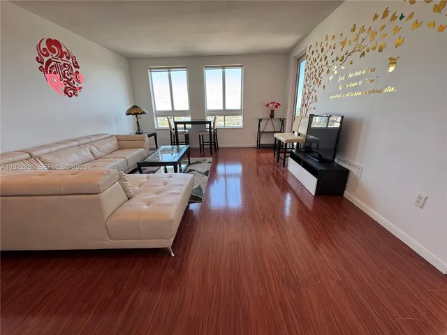 a living room with furniture and wooden floor