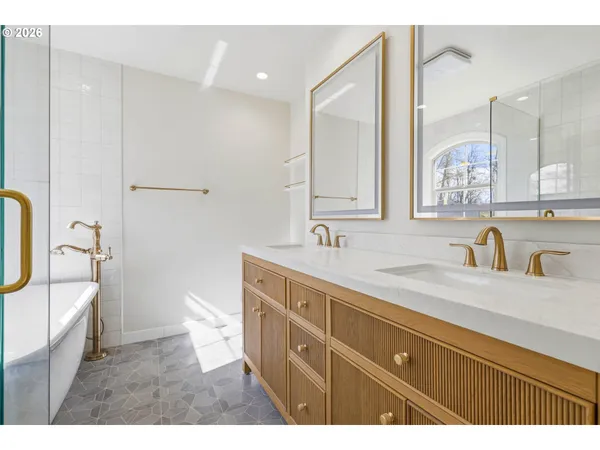 a bathroom with a tub a sink and glass door