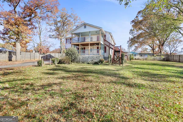 a view of a big house with a big yard and large trees