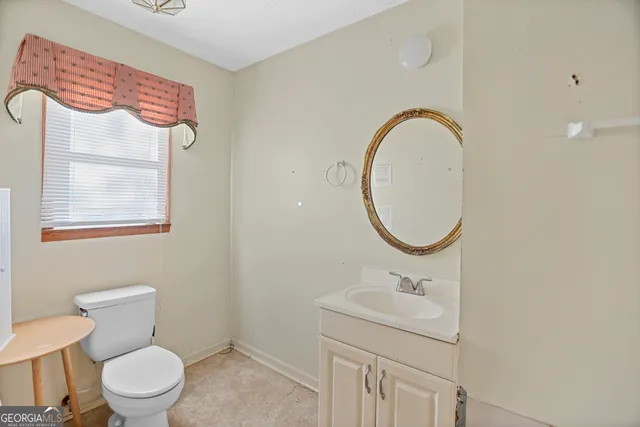 a bathroom with a sink a toilet and a mirror