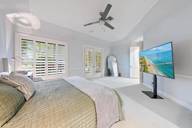 a spacious bedroom with a bed and a potted plant